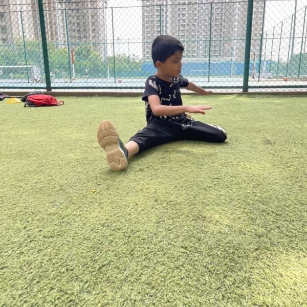 Junior athlete holding an L-sit flexibility stretch at VHR Sports