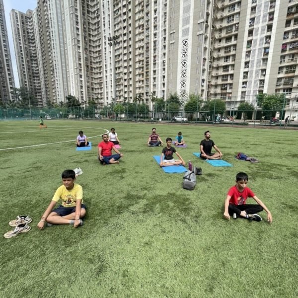 Group meditation session on the turf at VHR Sports, Lodha Amara