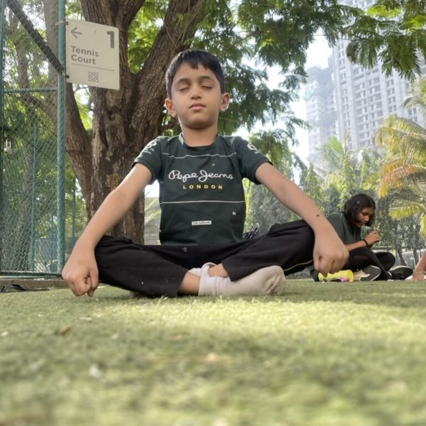 A young athlete meditating under a tree at VHR Sports, Lodha Amara